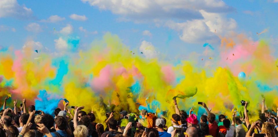 Festival crowd in clouds of coloured powder